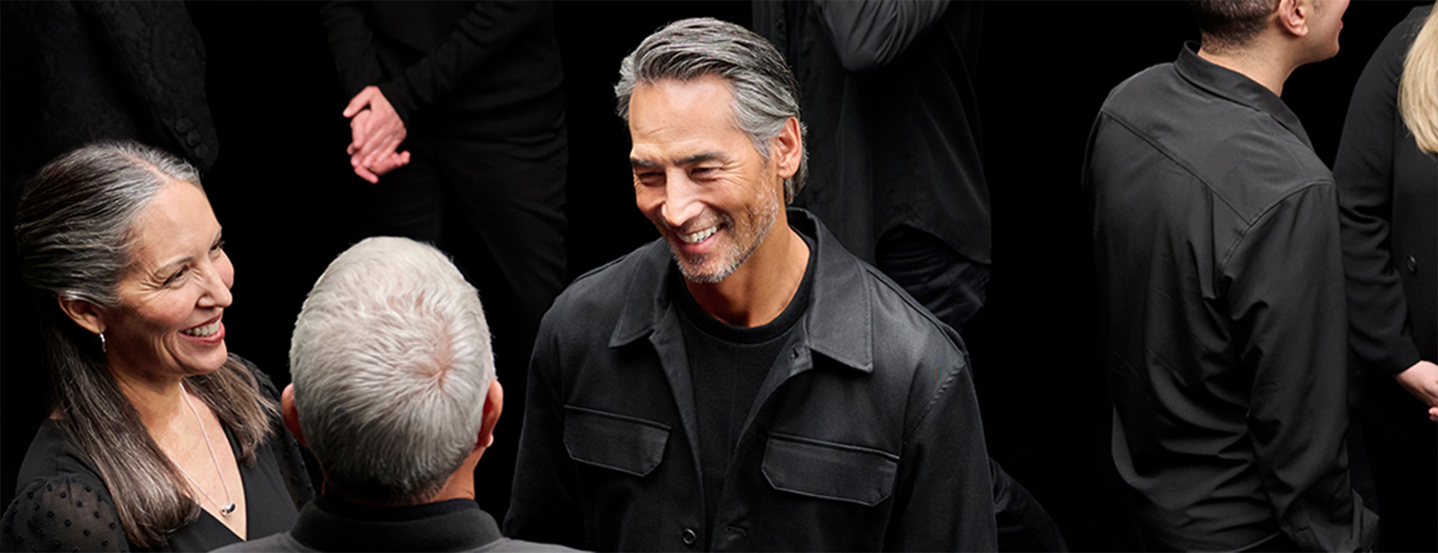 Image of a small group of middle aged males and a female chatting